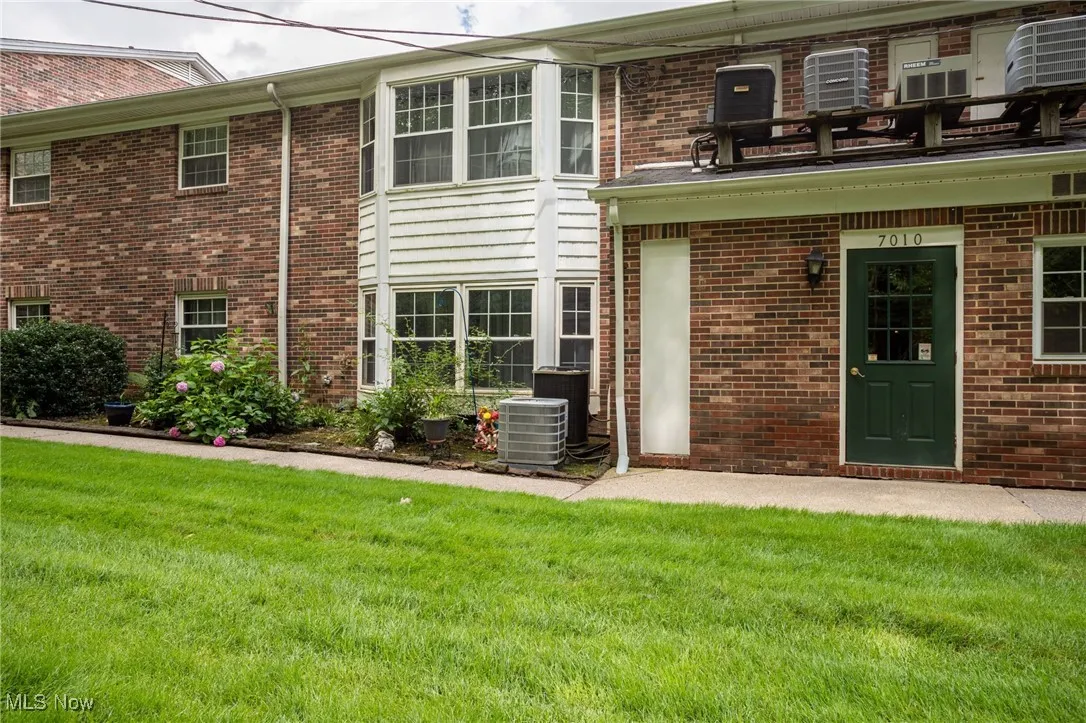 Property entrance with a lawn and brick siding