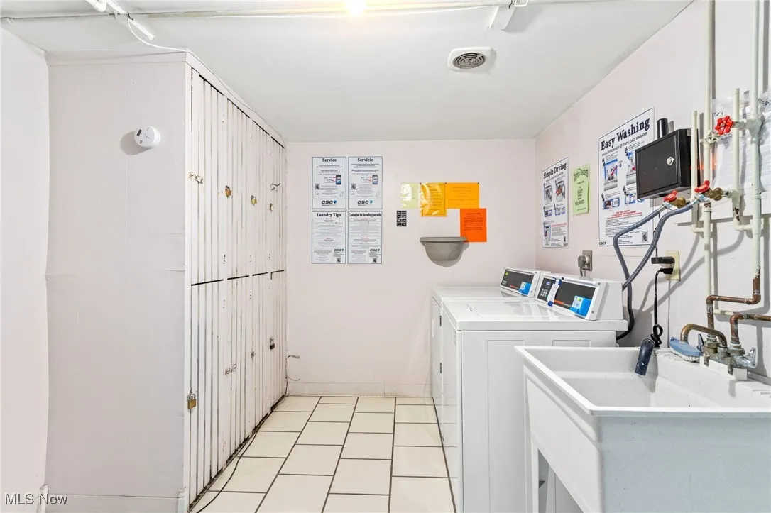Shared laundry room with light tile patterned flooring and independent washer and dryer