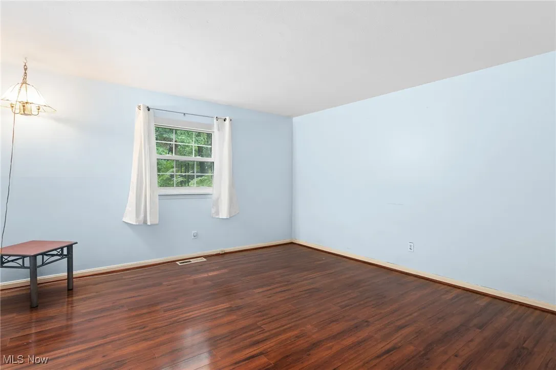 Unfurnished room with wood finished floors and baseboards