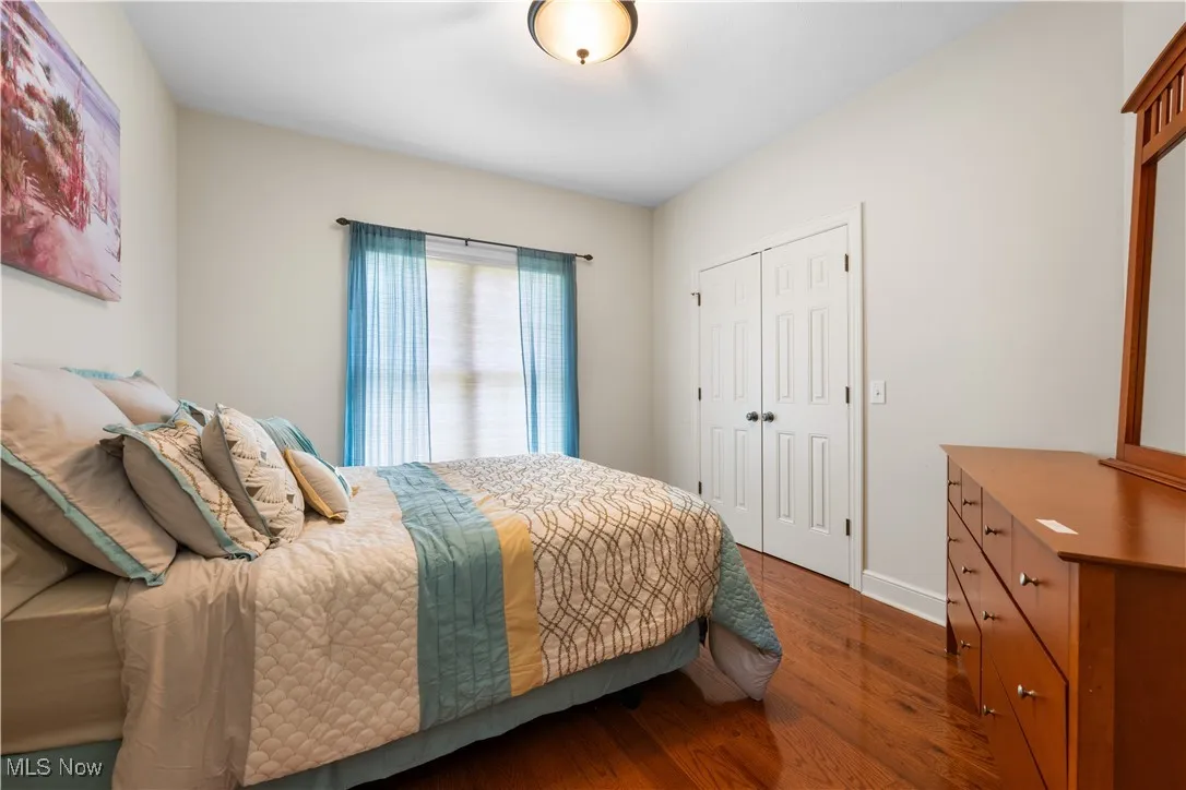Bedroom featuring dark wood-type flooring and a closet