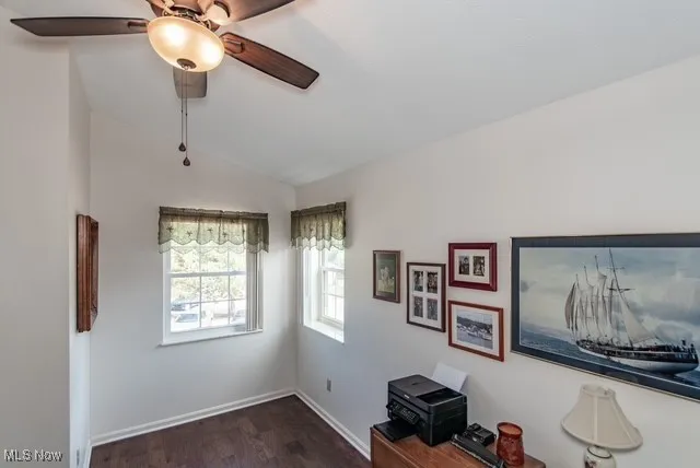 Office space with dark wood finished floors, lofted ceiling, and ceiling fan
