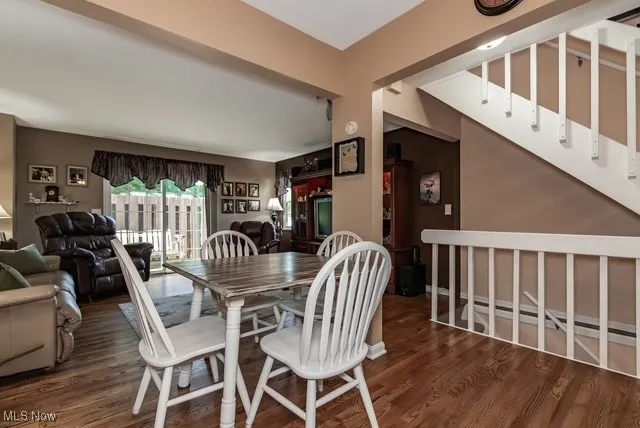 Dining room featuring dark wood-type flooring and stairway