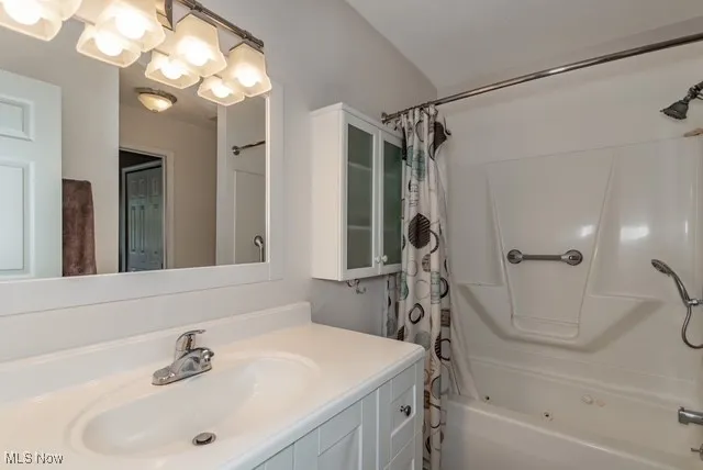 Full bath featuring shower / tub combo and vanity
