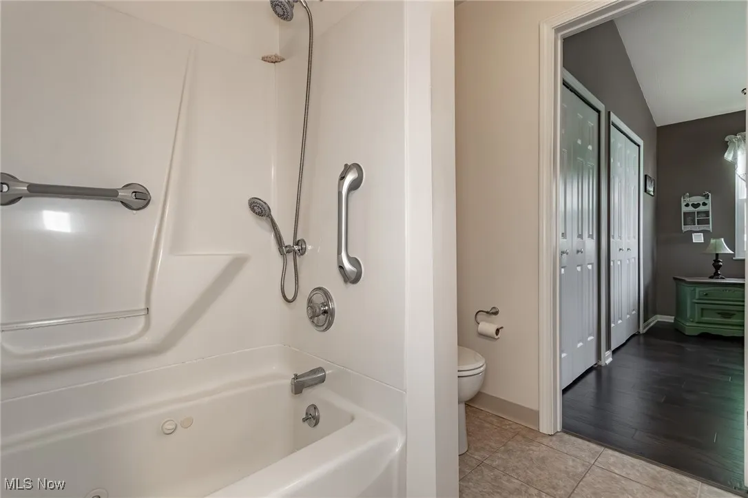 Full bathroom featuring shower / washtub combination, light tile patterned flooring, and a closet