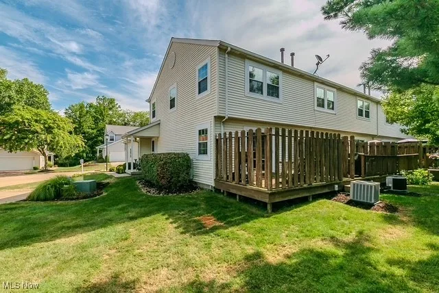 Back of property featuring a deck and a yard