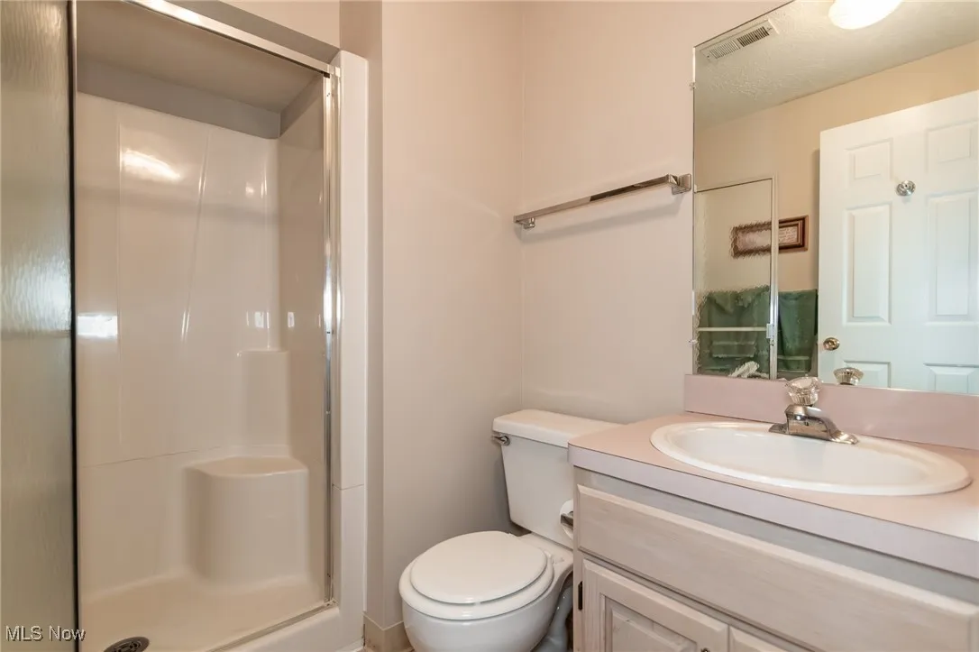Full bath with a shower stall and vanity