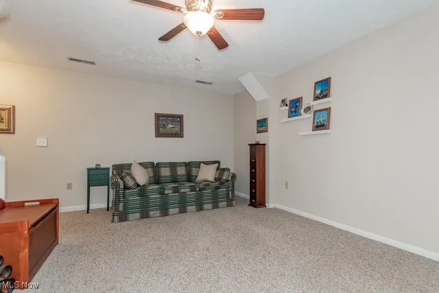 Living area with carpet and a ceiling fan