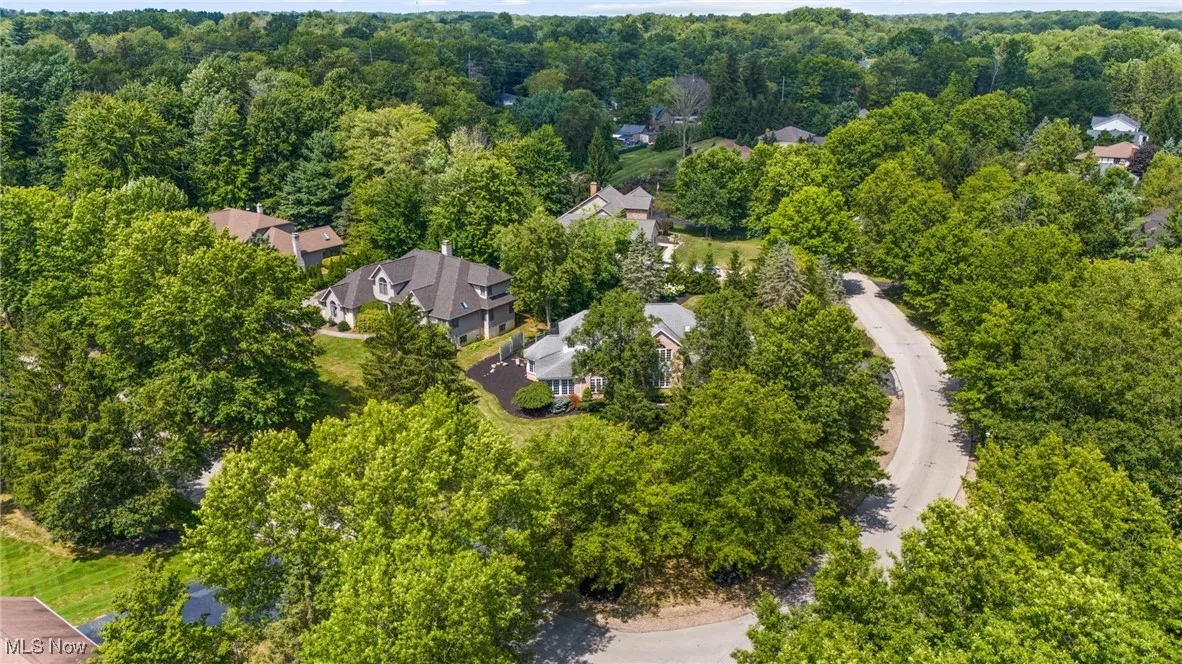 Aerial view of property and surrounding area featuring a forest
