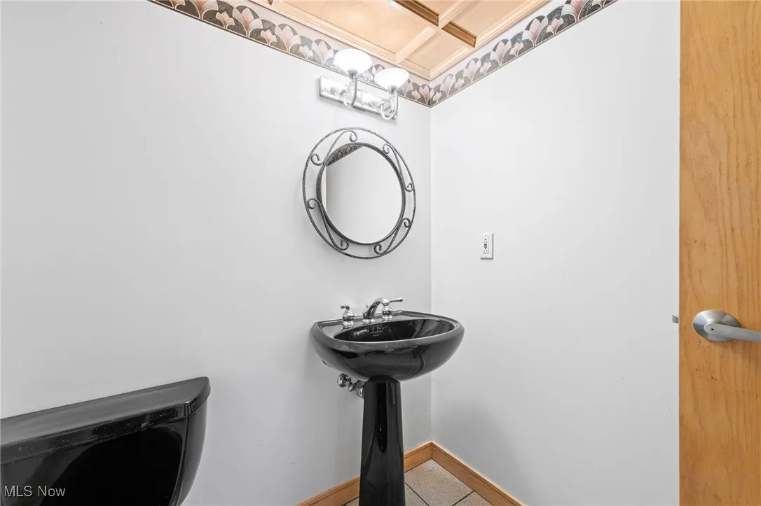 Bathroom with tile patterned floors and coffered ceiling