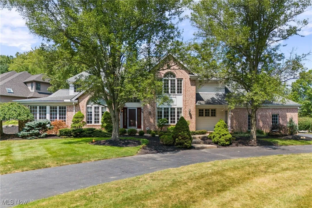 View of front of house featuring a front lawn and brick siding
