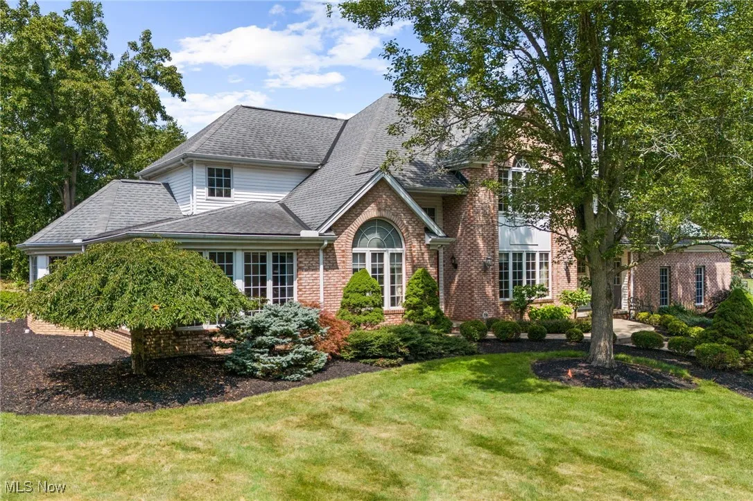 Traditional-style house with brick siding, and a front lawn
