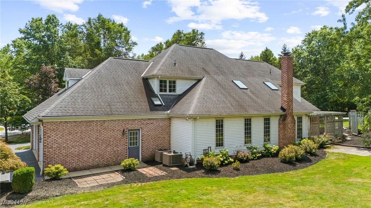 Back of property with a lawn, and brick siding