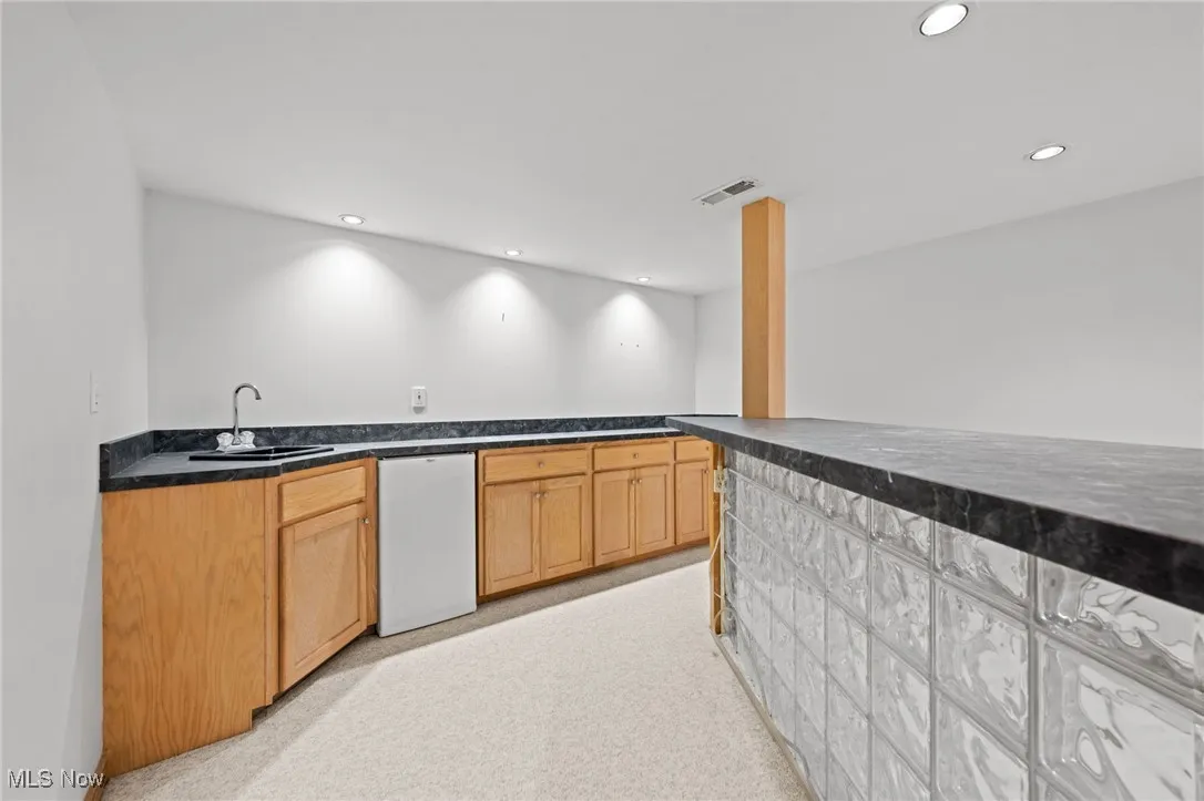 Bar area featuring white dishwasher and recessed lighting