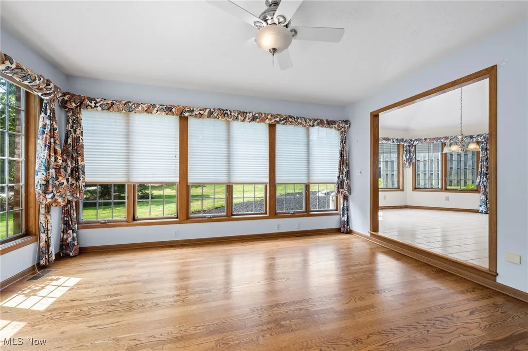 Unfurnished family room featuring healthy amount of natural light, light wood-style floors, and a ceiling fan