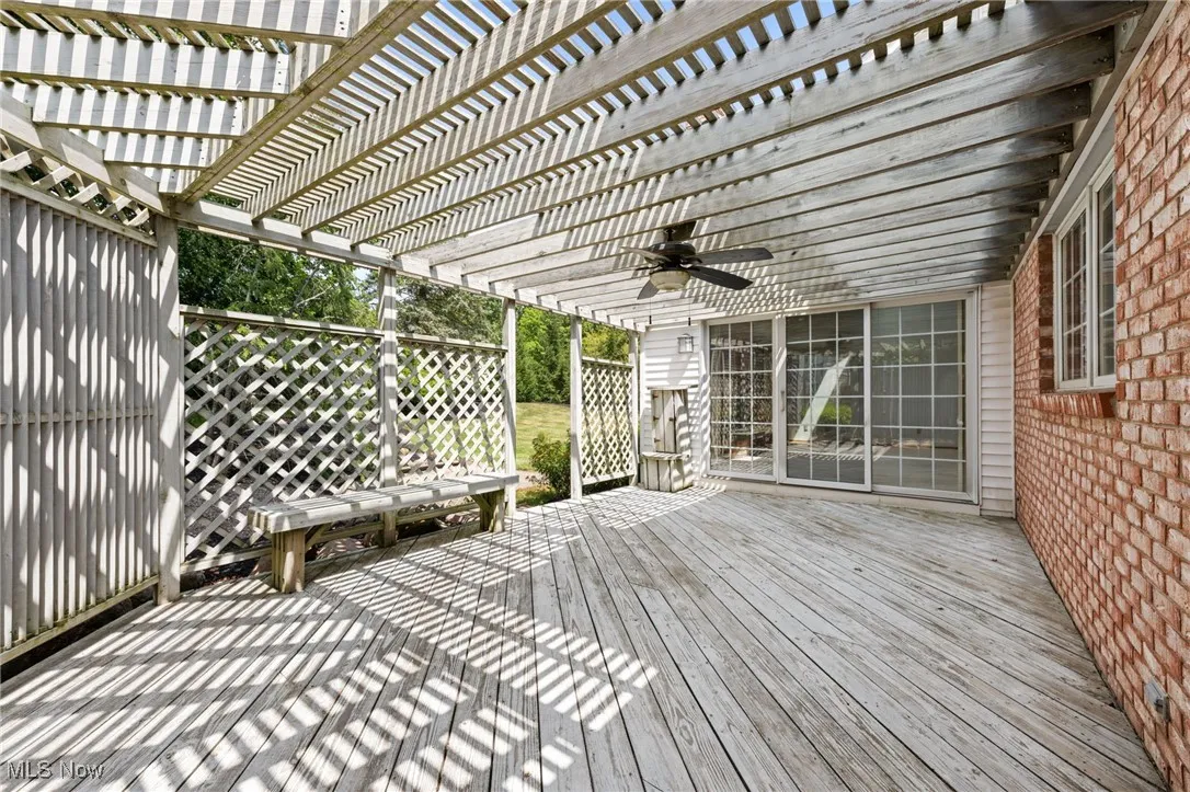 Wooden terrace featuring a ceiling fan and a pergola