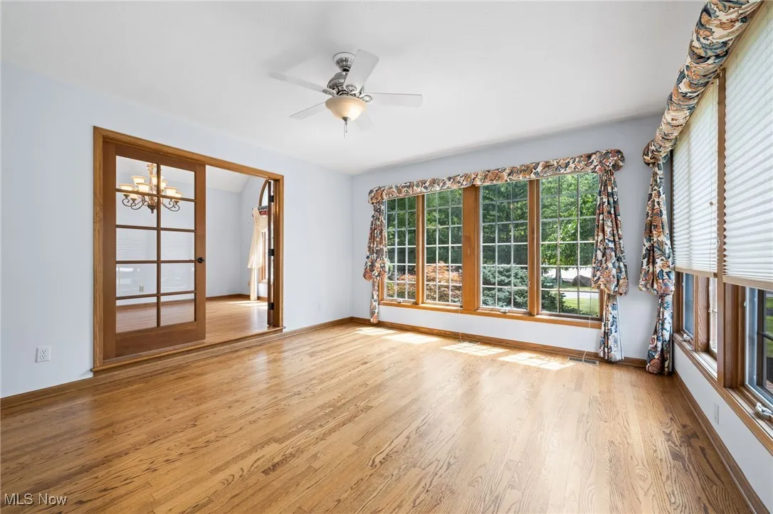 Unfurnished family room with wood finished floors, and a ceiling fan