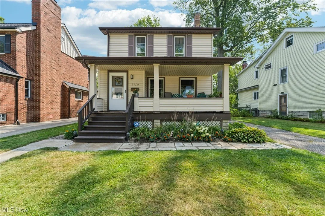 Traditional style home featuring covered porch, a front lawn, and a chimney