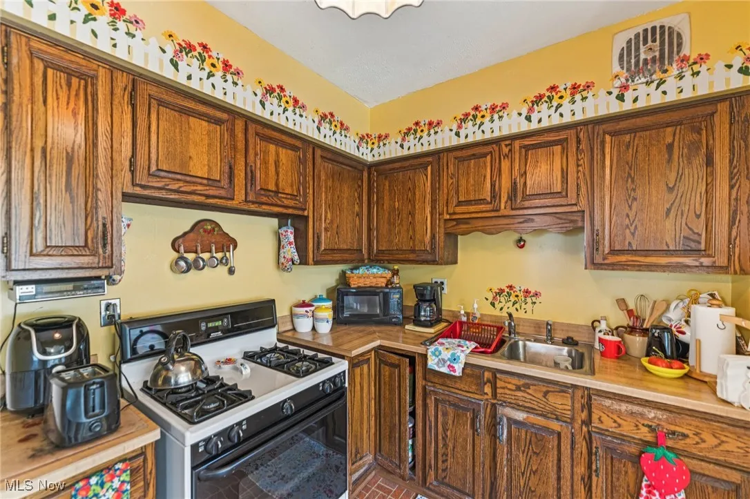 Kitchen with white gas stove and light countertops