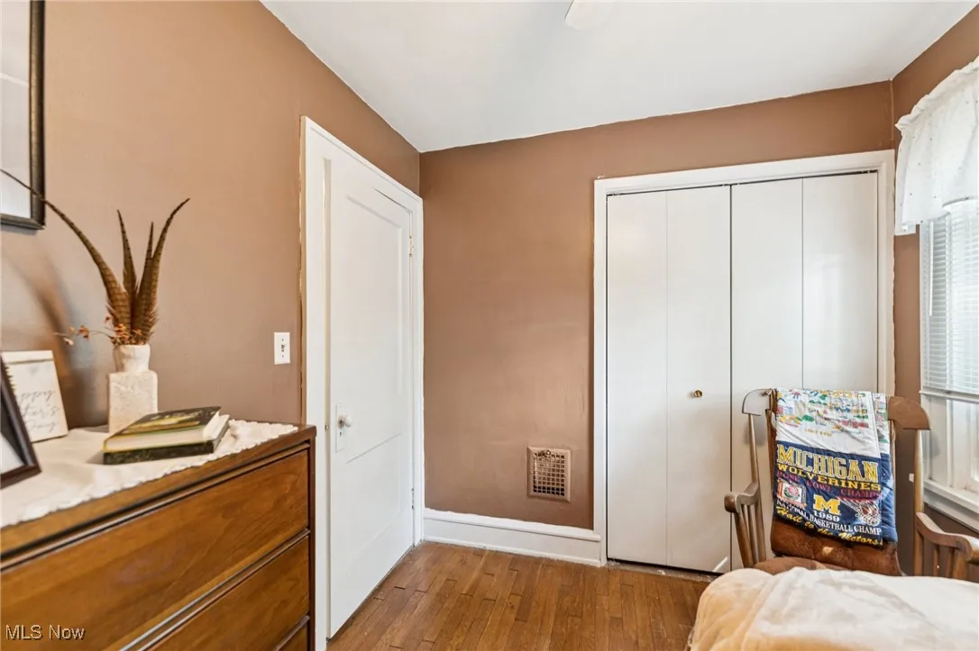 Bedroom with dark wood-style flooring, a closet, and ceiling fan
