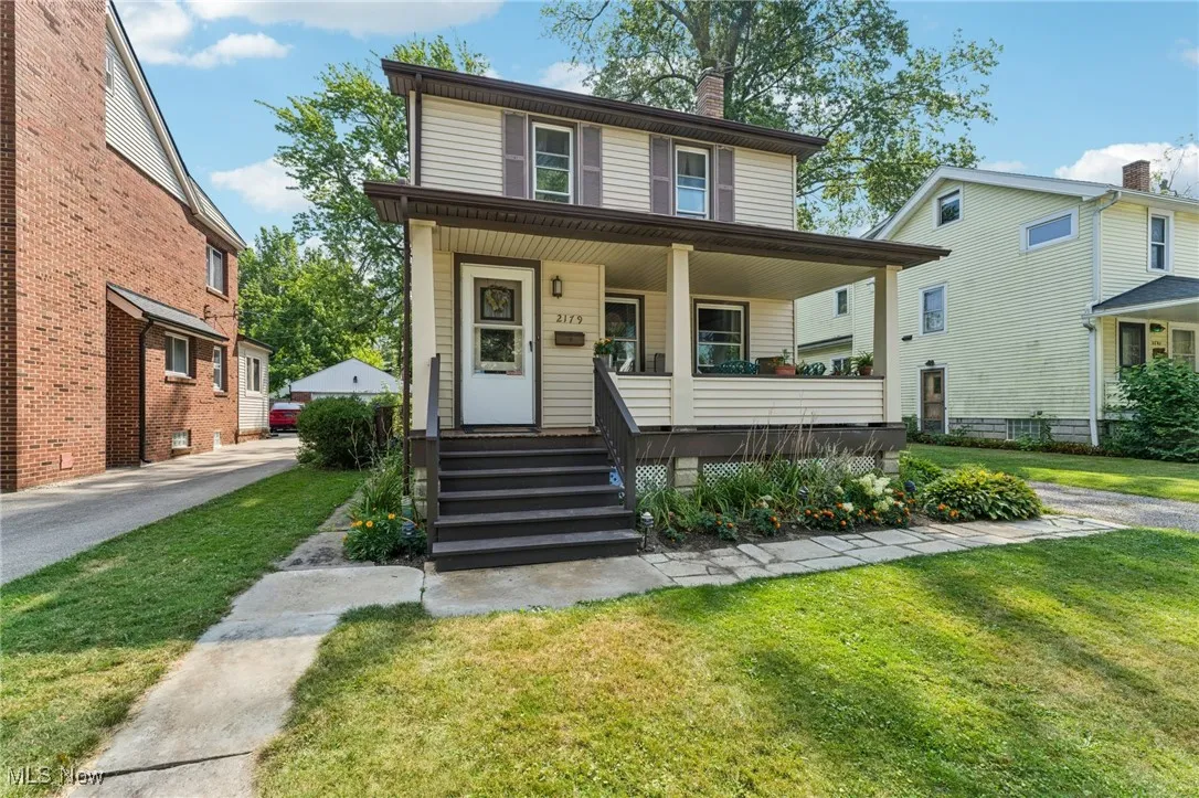 American foursquare style home with a front yard, covered porch, and a chimney