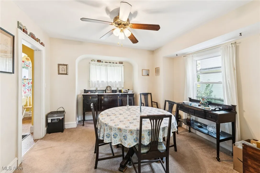 Dining area with light colored carpet and ceiling fan