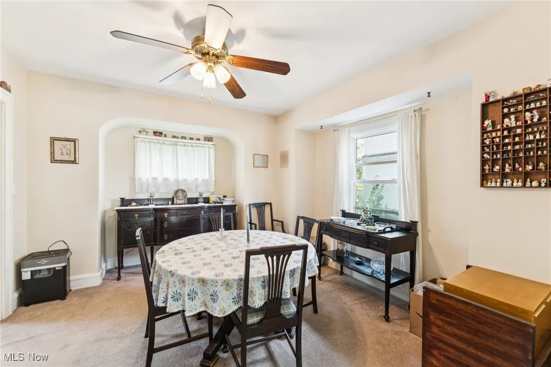 Dining room with light colored carpet and a ceiling fan