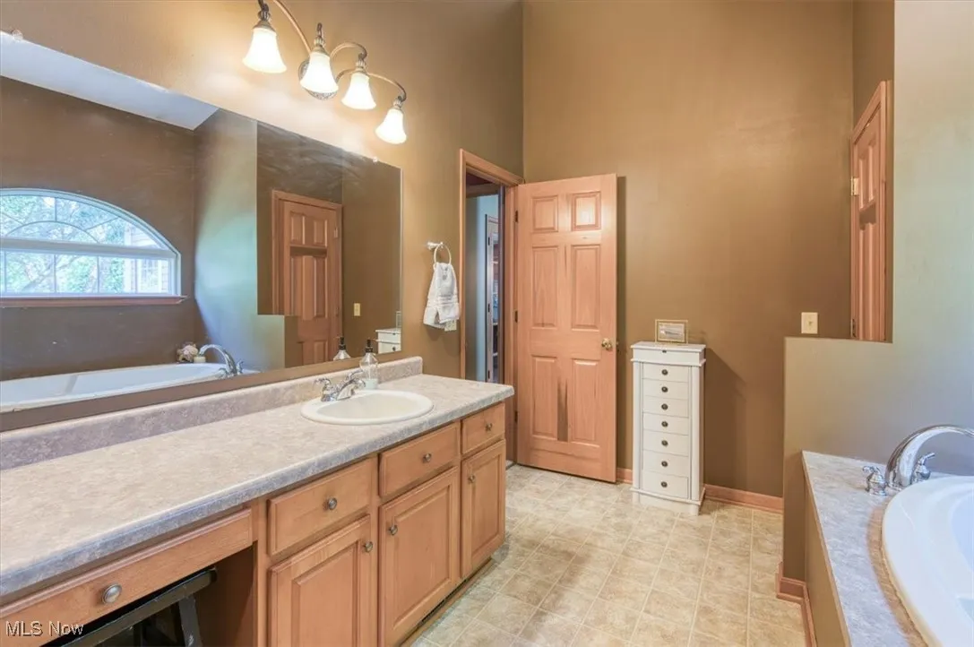 Full bathroom featuring vanity and a garden tub