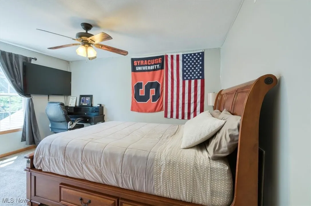 Carpeted bedroom featuring a ceiling fan