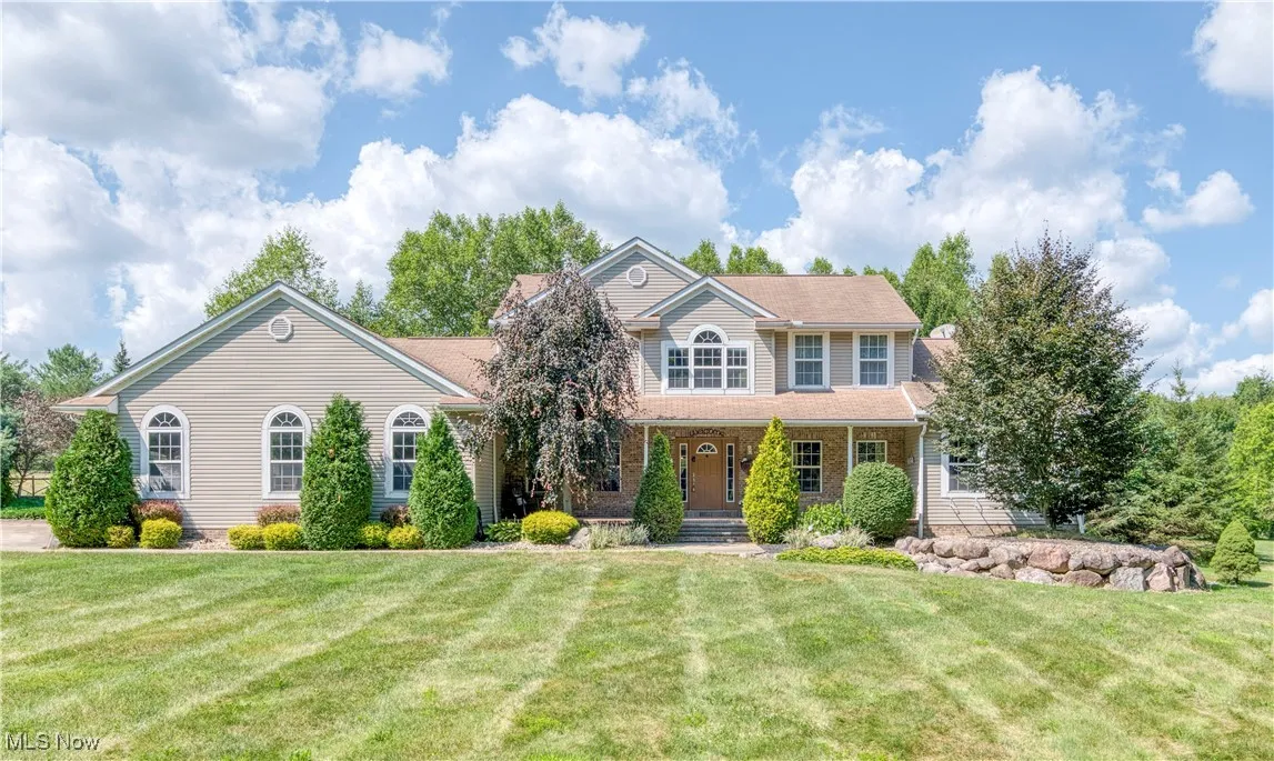 Colonial-style house with a porch and a front lawn