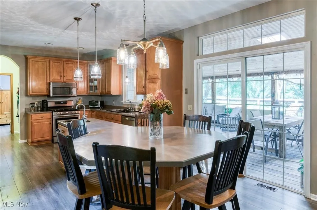 Dining area with dark wood-type flooring and arched walkways