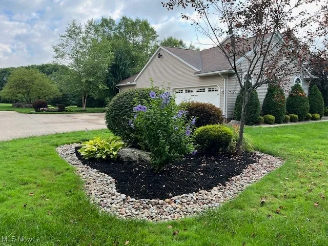 View of home's exterior featuring a lawn and a garage