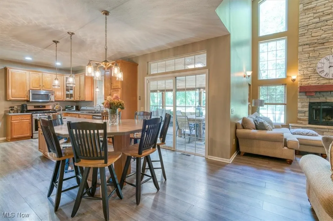 Dining area with light wood finished floors, healthy amount of natural light, and a fireplace
