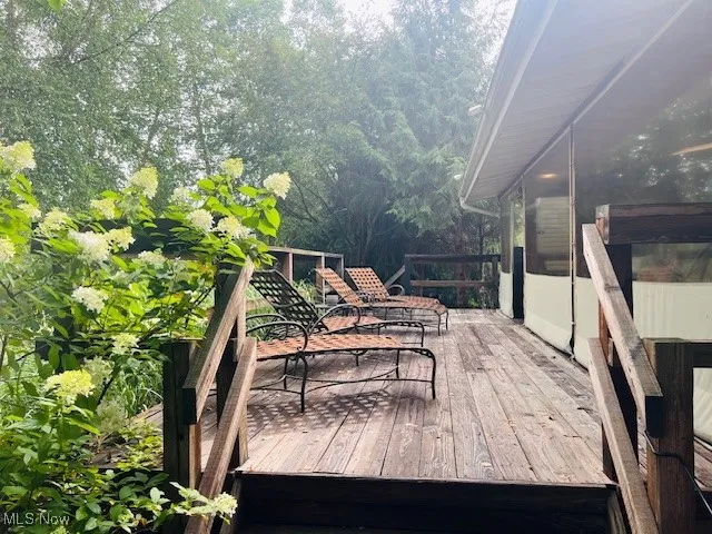 Wooden terrace featuring view of wooded area