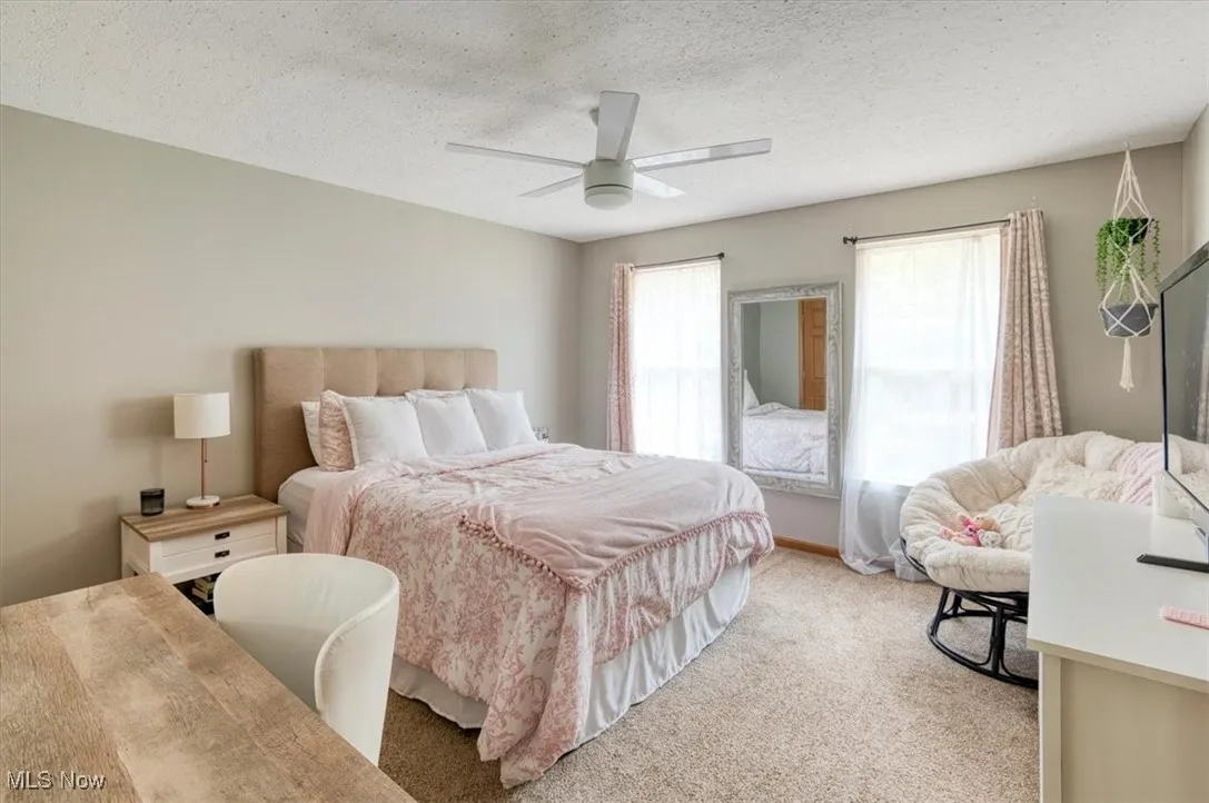 Bedroom with carpet, a textured ceiling, and ceiling fan