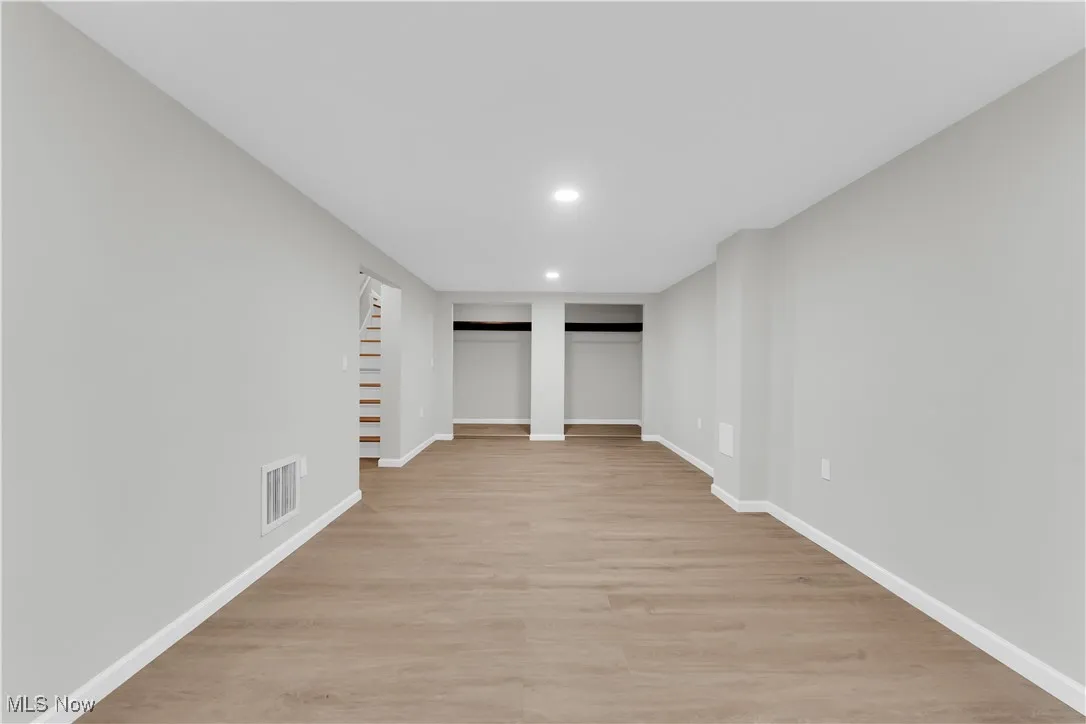 Finished basement featuring light wood-type flooring and recessed lighting