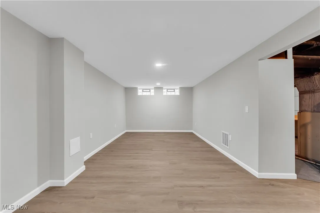 Below grade area with light wood-style flooring and baseboards