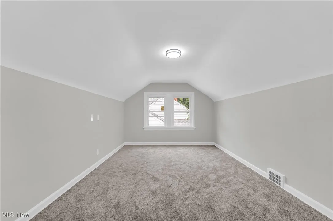 Additional living space with carpet and lofted ceiling