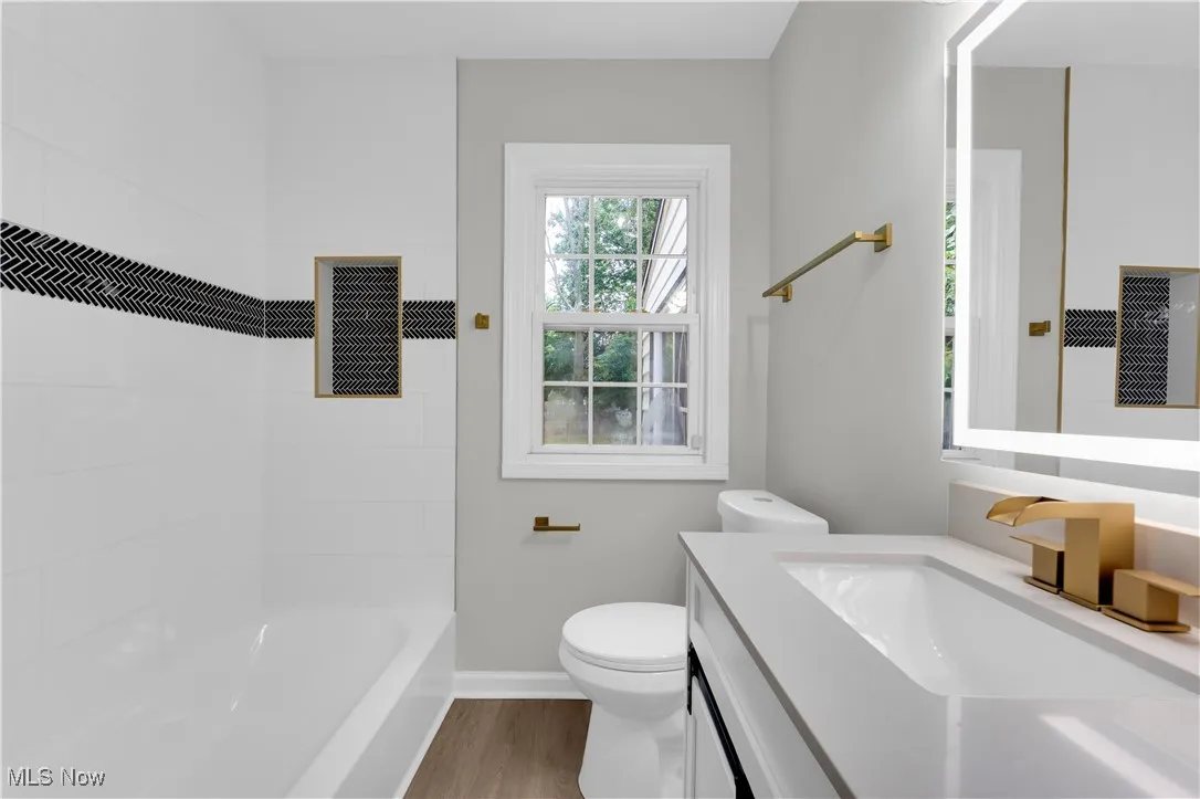 Bathroom featuring vanity, light wood finished floors, and  shower combination
