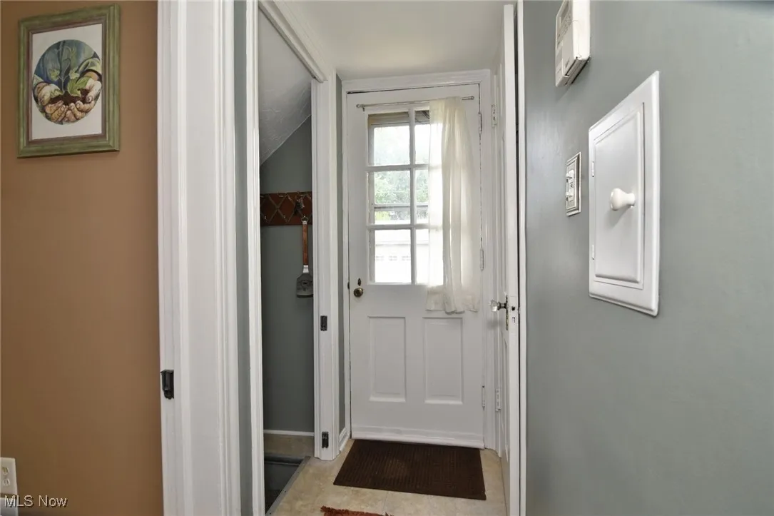 Doorway with baseboards and lofted ceiling