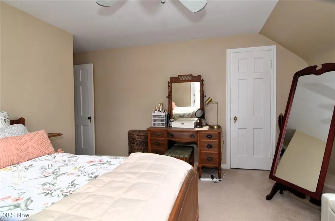 Bedroom with light carpet and a ceiling fan