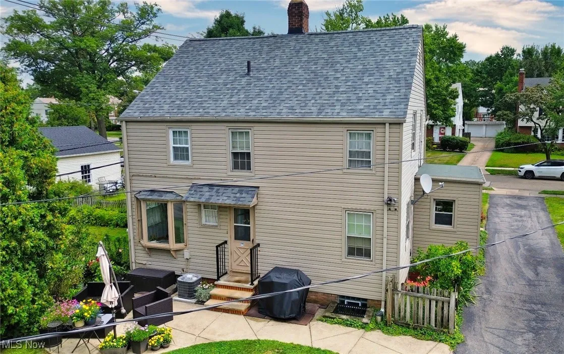 Rear view of property with a chimney, a shingled roof, entry steps, and an outdoor living space