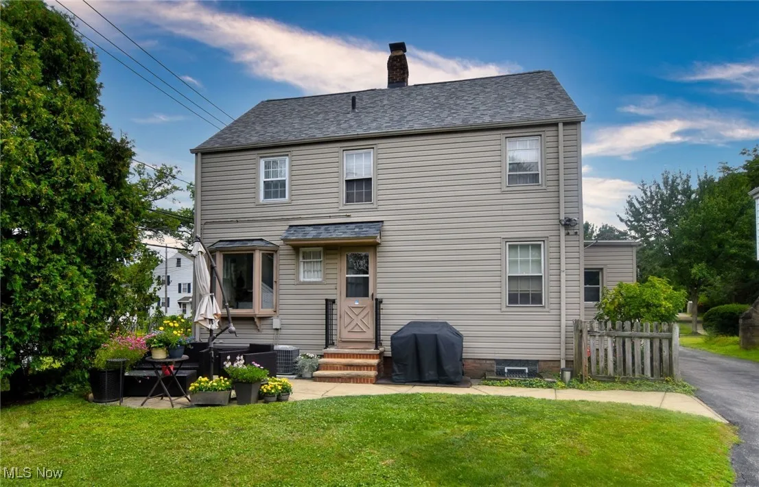 Back of property featuring a chimney, a shingled roof, and entry steps