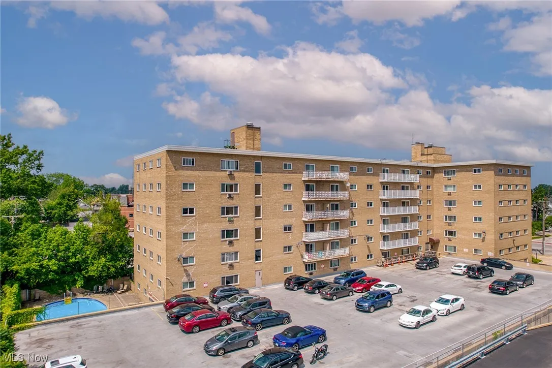 View of apartment building / complex with uncovered parking
