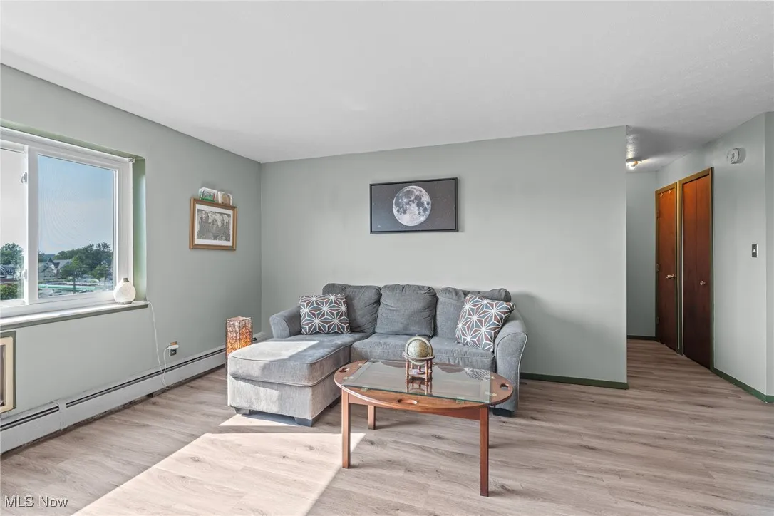Living room with wood finished floors and a baseboard radiator