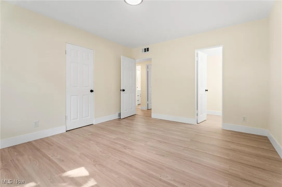 Unfurnished bedroom with light wood finished floors and baseboards