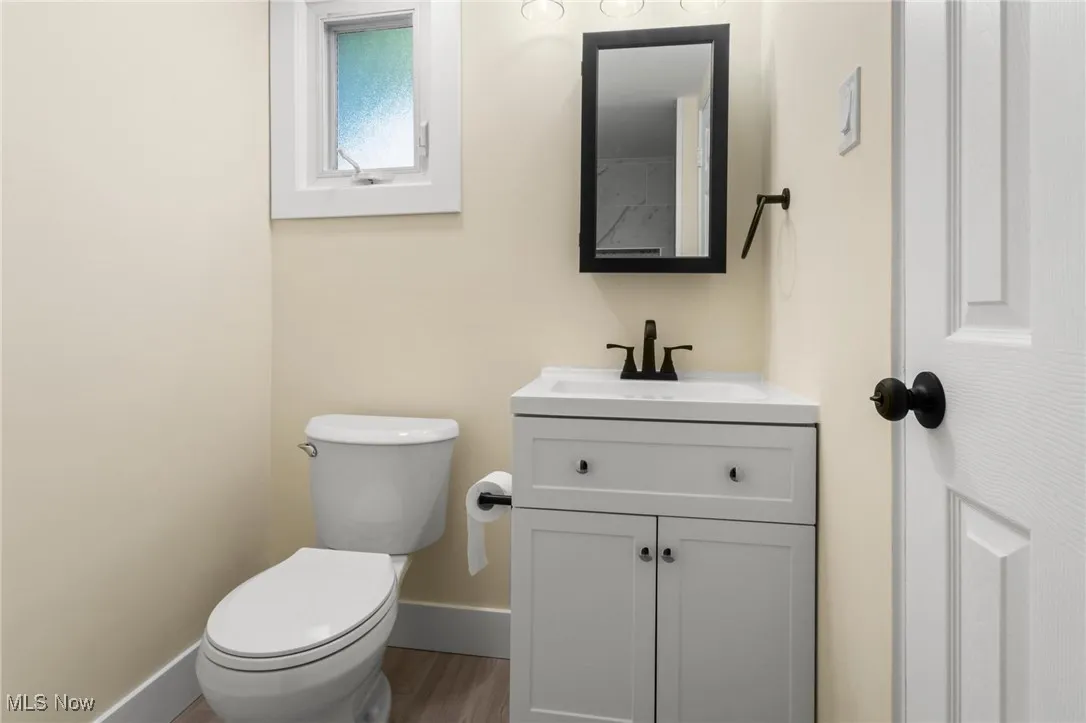 Half bath featuring vanity and wood finished floors