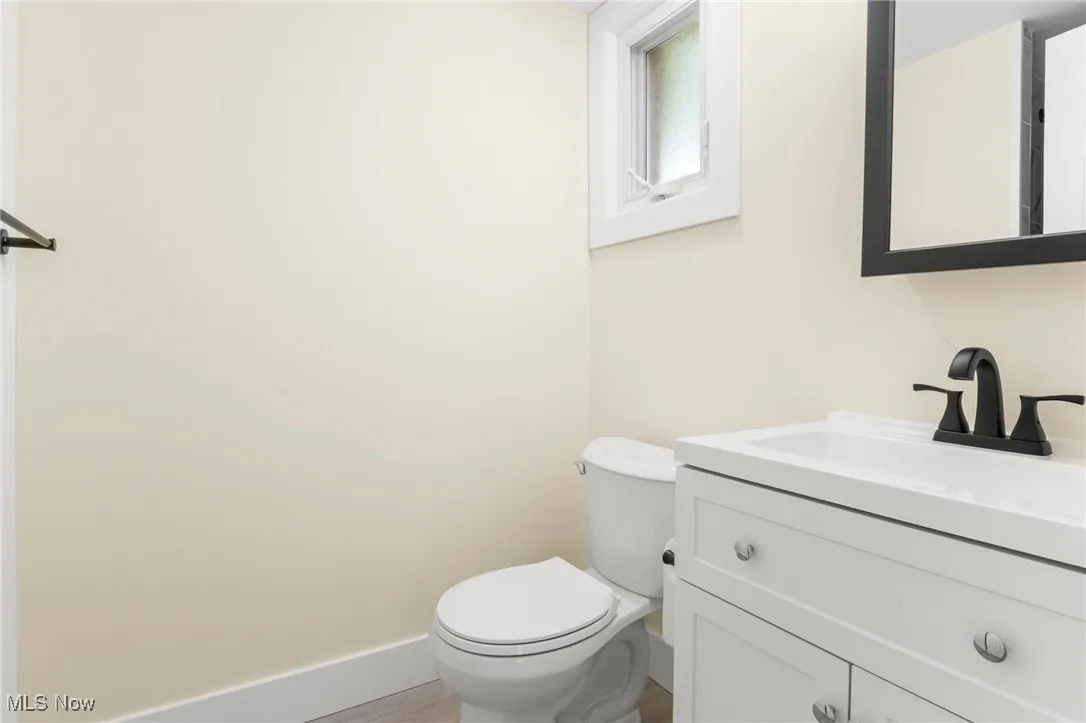 Half bathroom featuring vanity and wood finished floors