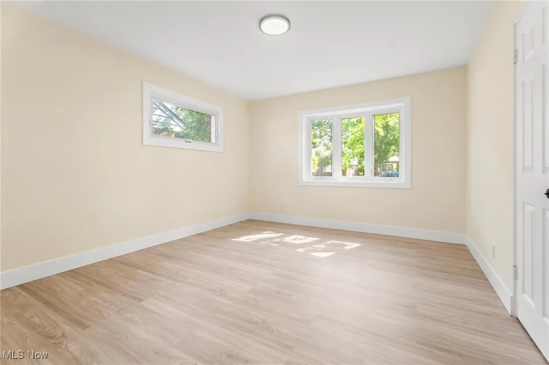 Unfurnished bedroom featuring multiple windows and light wood finished floors