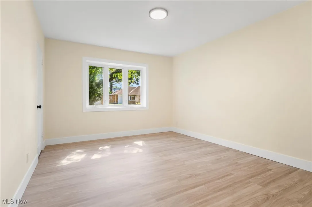 Unfurnished room featuring light wood finished floors and baseboards