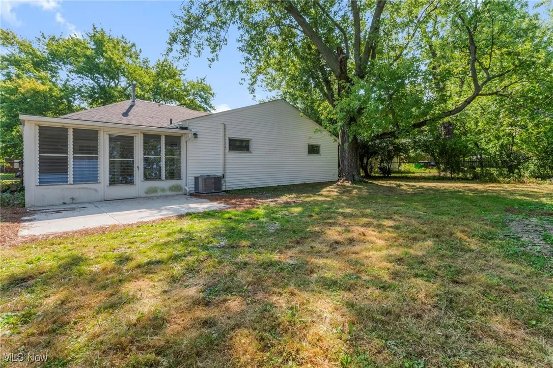 Back of property with a patio and a lawn